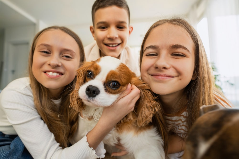 Crianças abraçando cachorro